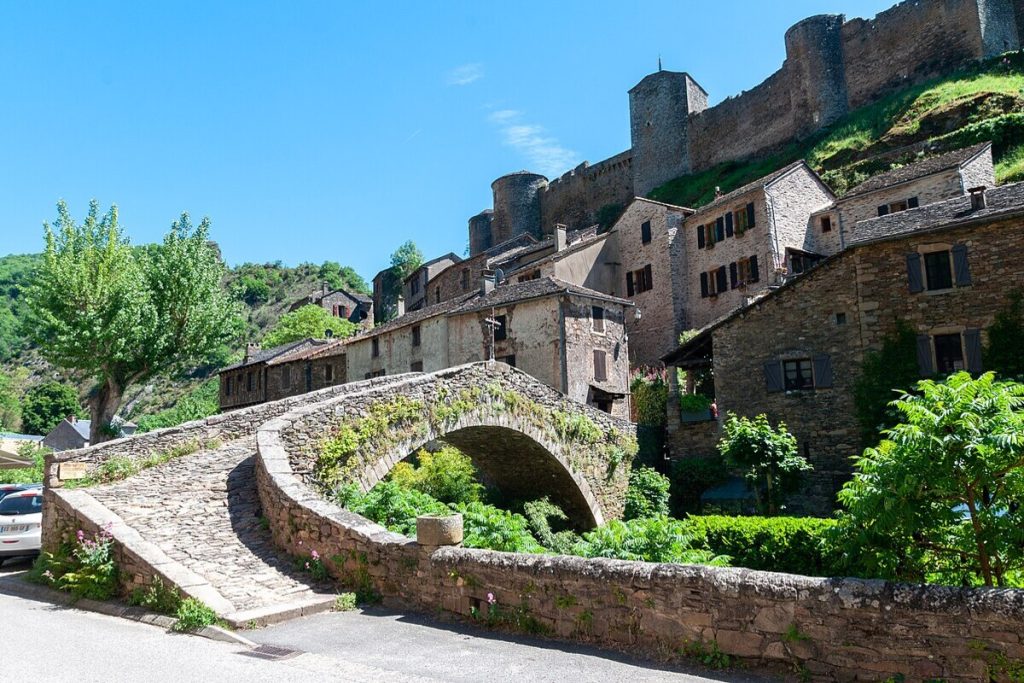 le tarn révèle ce plus beau village de france, une forteresse de briques roses suspendue au dessus de la rivière
