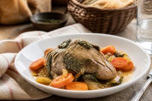 Tranches de cœur de veau poêlées, dorées et rosées à cœur, servies avec une sauce au persil et à l'ail dans une poêle en fonte